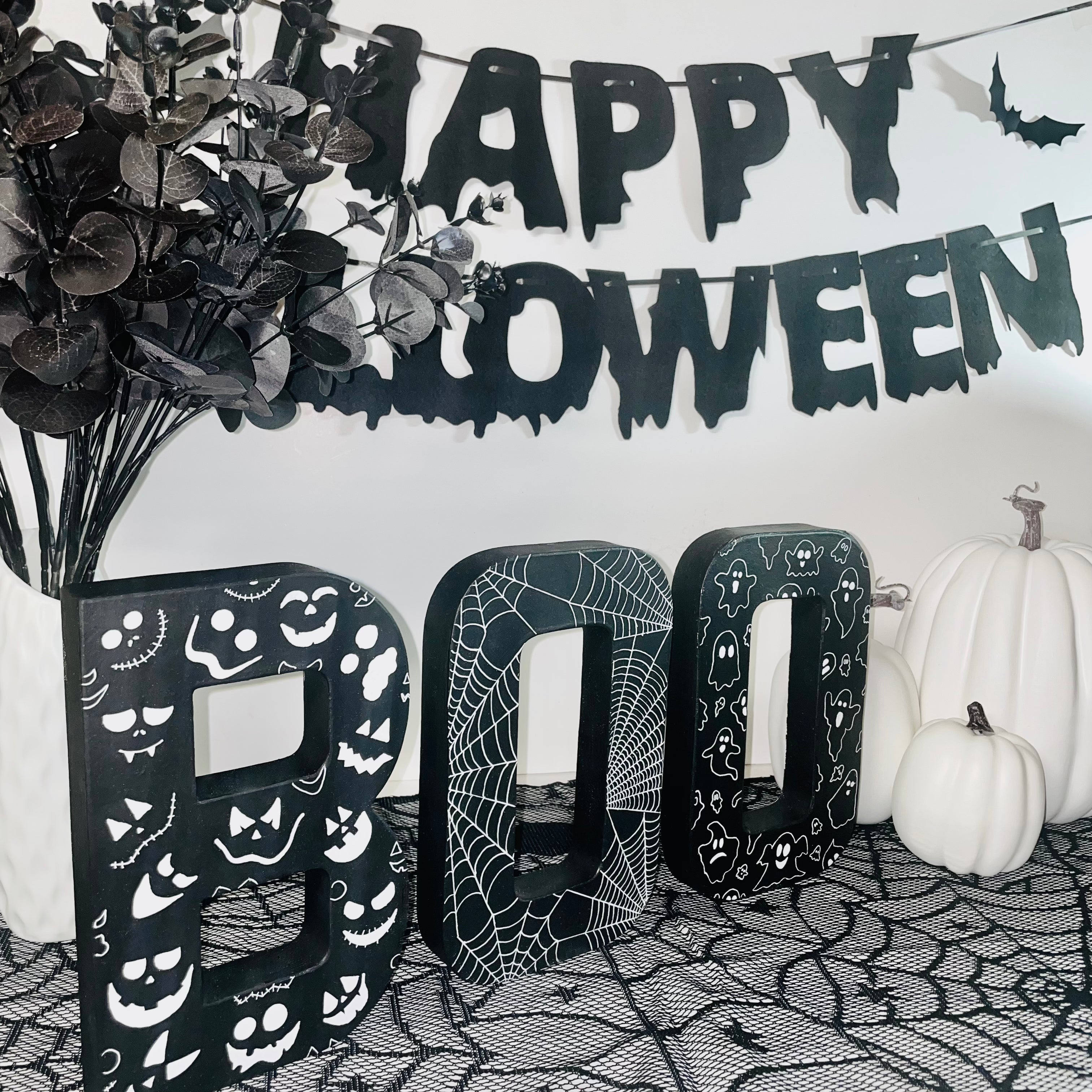 Black BOO Letters Decorated with white Pumpkin Faces, Spider Webs & Ghosts. Halloween Party Sign Decor. Freestanding Letters