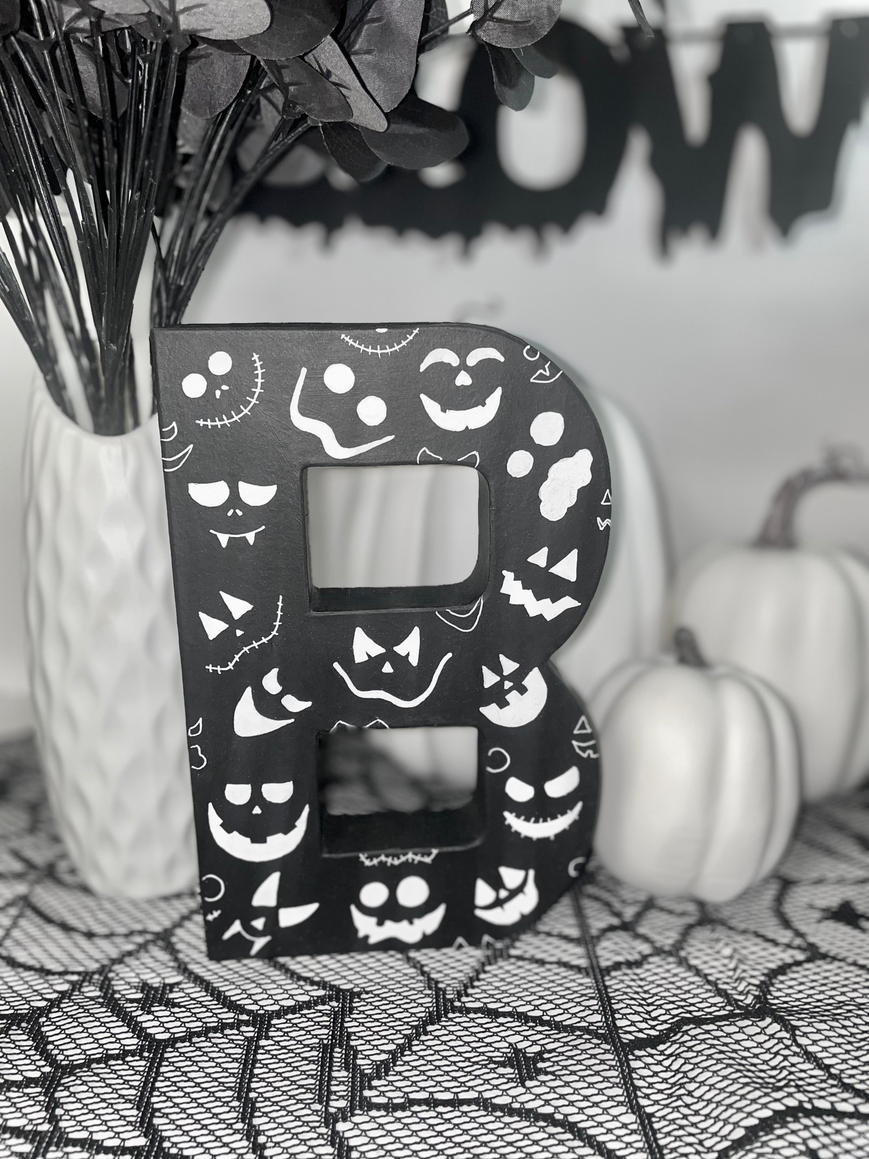 Black Letter B Decorated with white Pumpkin faces. Handmade Halloween Decor. Freestanding Letters