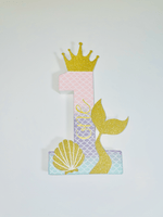 Load image into Gallery viewer, Decorative number &#39;1&#39; with a gold glitter crown, mermaid tail, and shell on a white background
