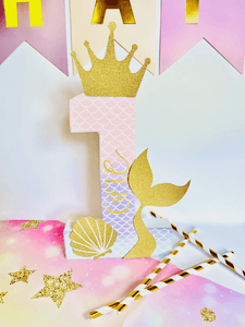 Ombre mermaid themed number '1' with a gold glitter crown, mermaid tail, and shell on a colourful background.